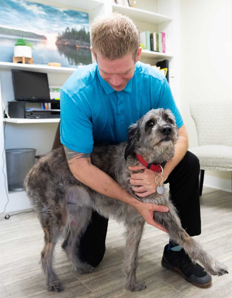 Dr. Seth Nelson providing gentle animal chiropractic care to a dog in St. Peter MN