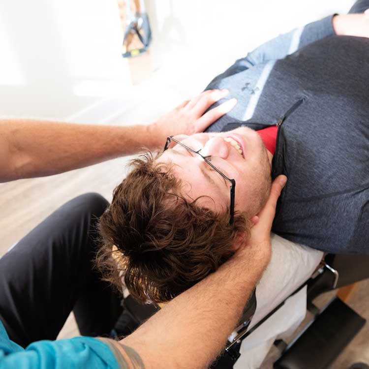 Chiropractic-Neck-Pain-Evaluation-St-Peter-MN Dr. Nelson performing a clinical neck evaluation and cervical range of motion test on a patient at Rising Sun Chiropractic in St. Peter, MN.